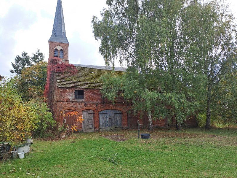Stall und Kirche im Hintergrund